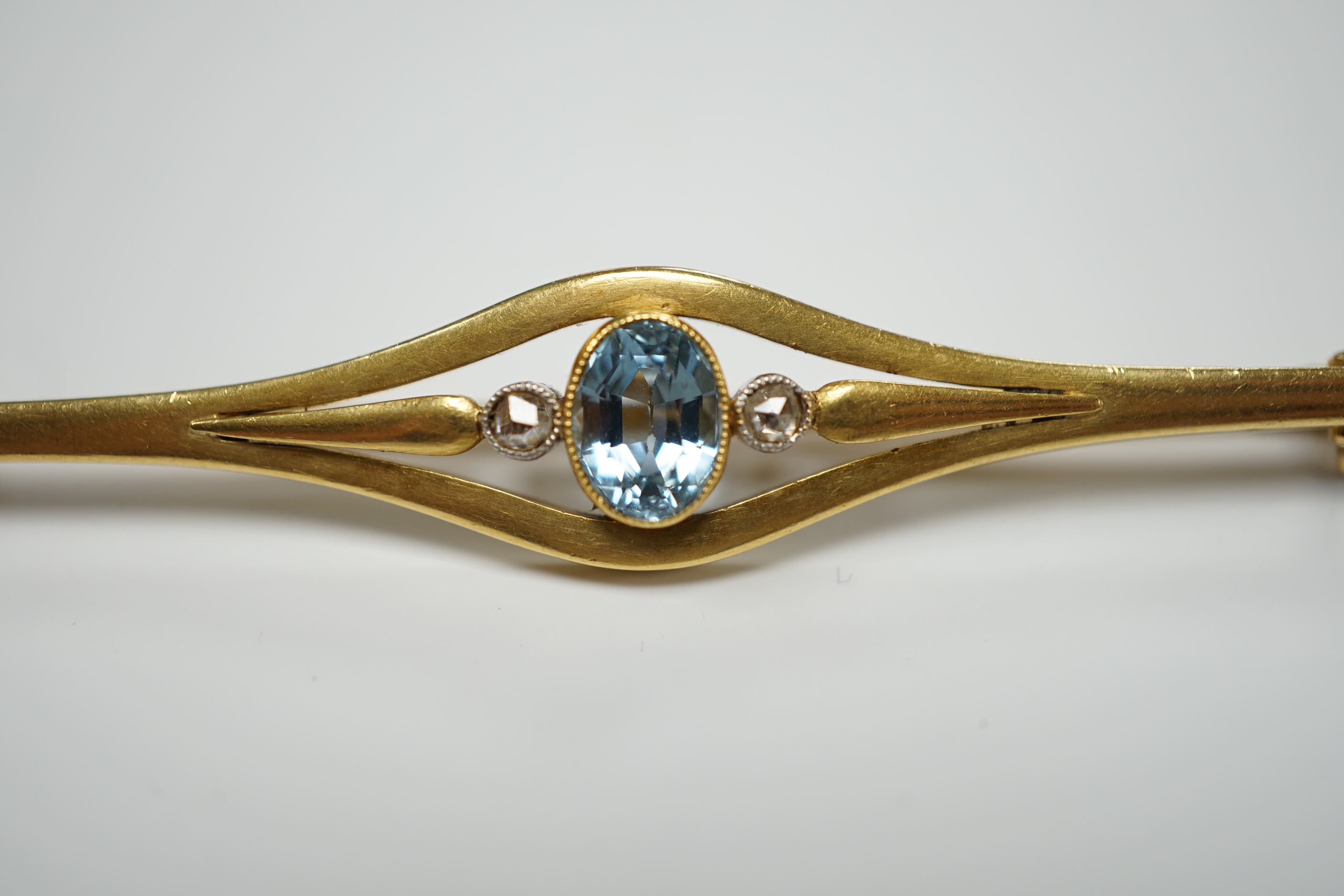 An early 20th century French yellow metal (18ct poincon mark), aquamarine and rose cut diamond set three stone bar brooch, 71mm, gross weight 9.1 grams.